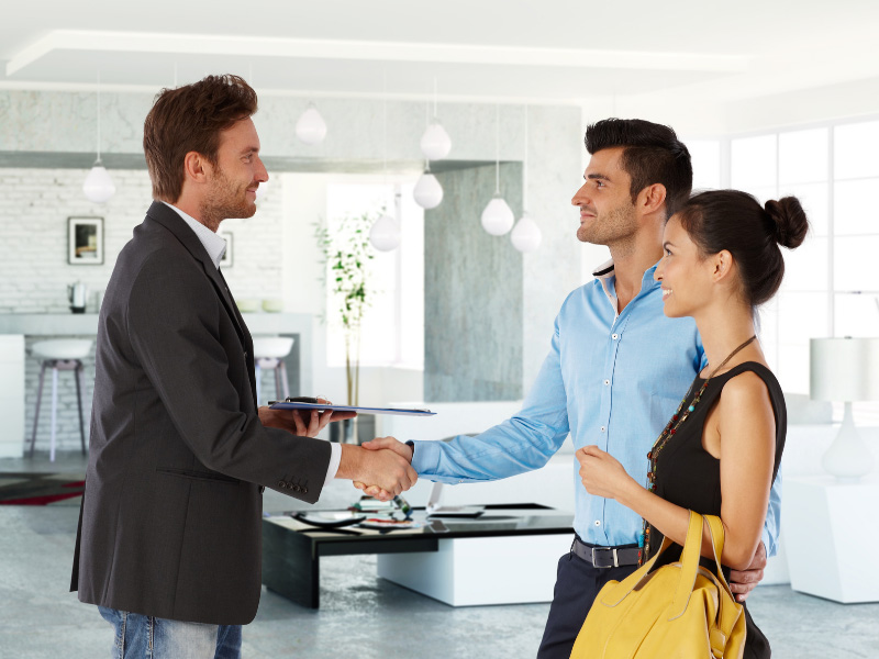 An image of a couple shaking hands with an estate agent