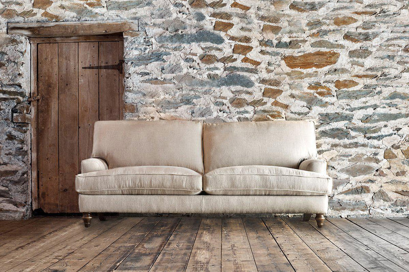 An image of a sofa against a stone brick wall