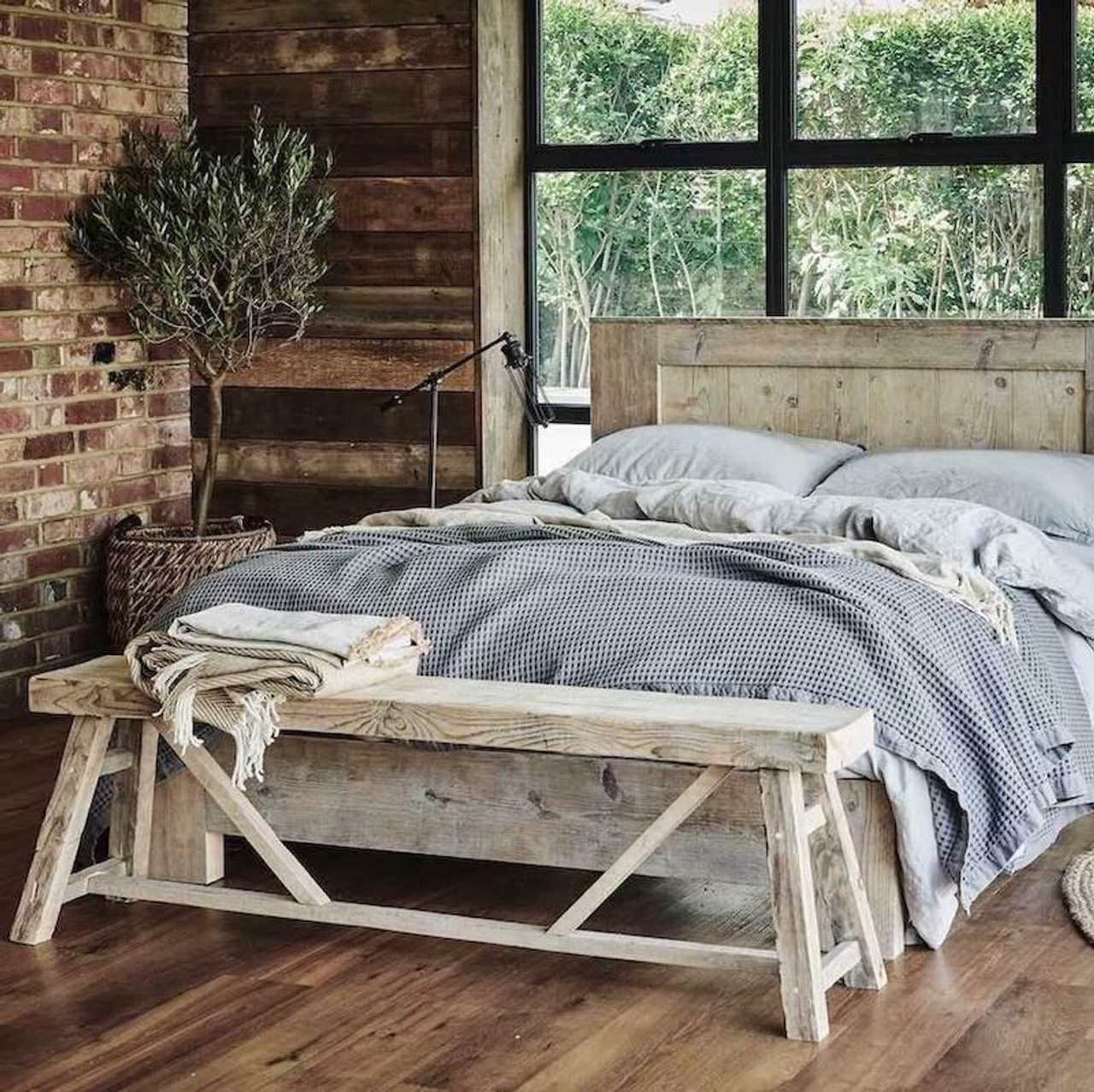 An image of an aged wooden bed frame with bed made