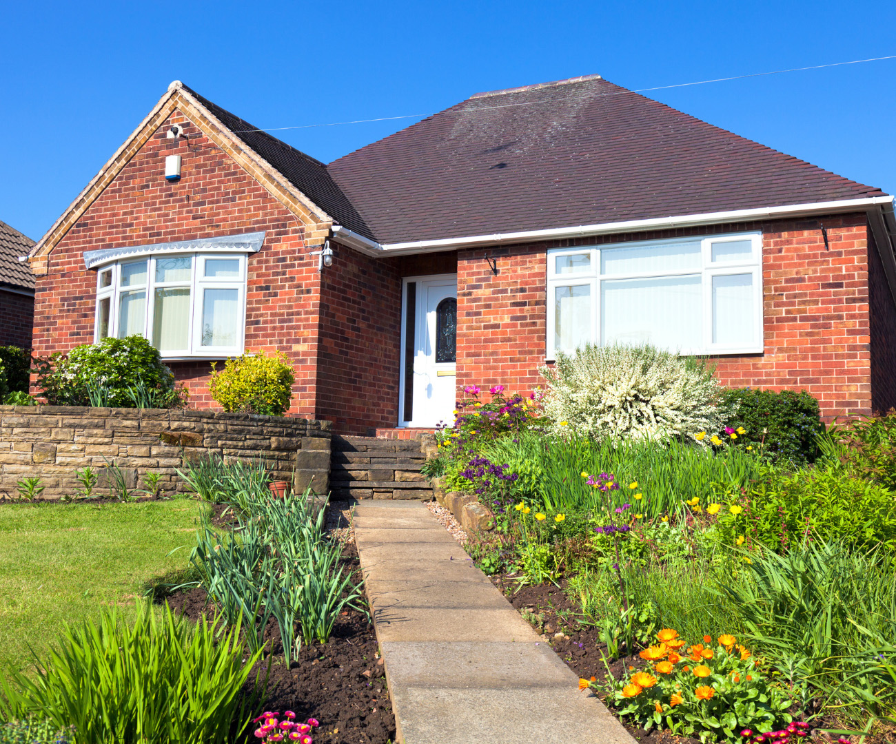 An image of a house with footpath and garden