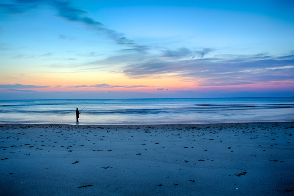 An image of someone fishing on the beach